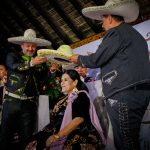 El presidente, José Antonio Salcedo, y el tesorero de Federación, Rafael Alberto Rodríguez, coronan a la reina de charros mayores, Rosa Angélica I
