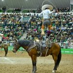 Ramiro Márquez de Rancho El Diamante "A" ejecutando su pasada sobre el caballo para emocionar al respetable