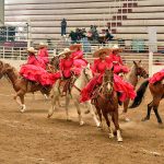 Las integrantes de la escaramuza El Renacer de Georgia deshojando una flor denominada «Gema»