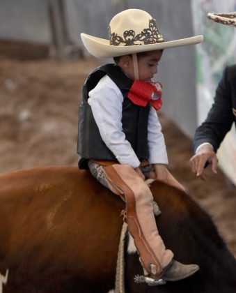 El jinete de toro de la Escuela Municipal de Tlajomulco, Mateo Carreón Bailón, recibe instrucciones para desmontarse del jurel una vez consumada su terna